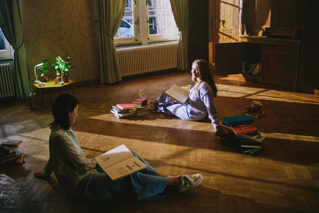 Campagne beeld van Sanature waarbij twee vrouwen op de grond zitten omringd door boeken
